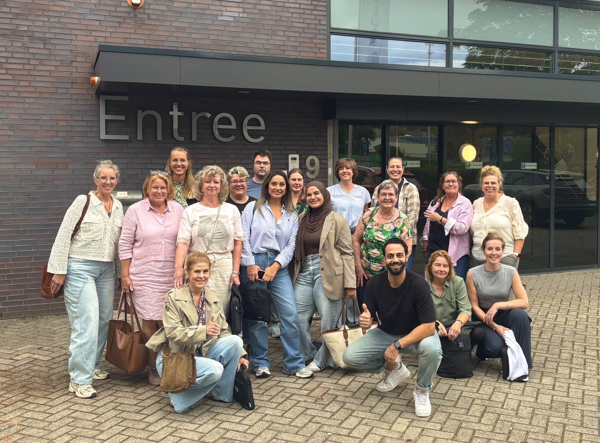 Grote groep deelnemers buiten bij de entree