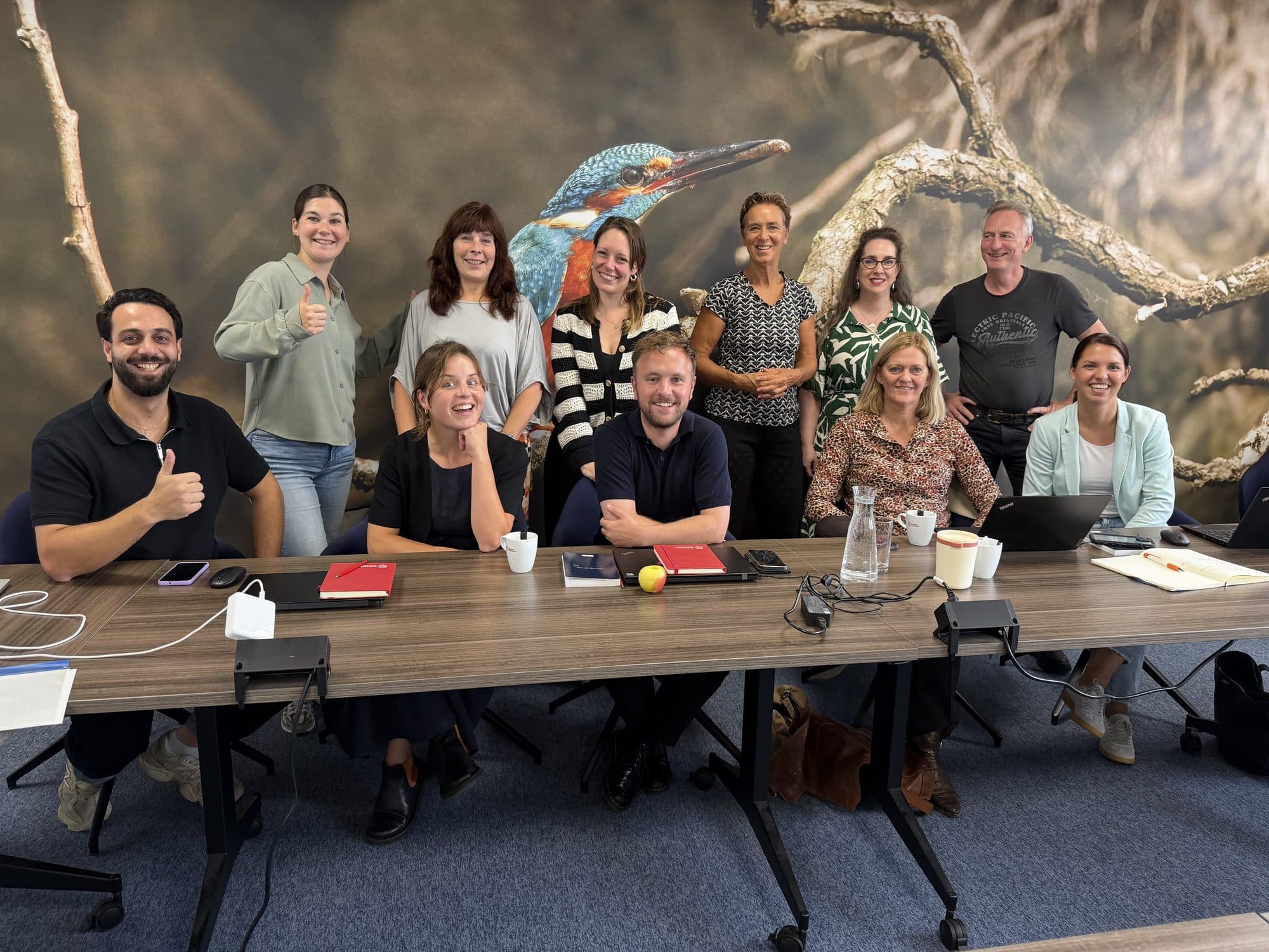 Deelnemers van een workshop aan tafel met hun laptops